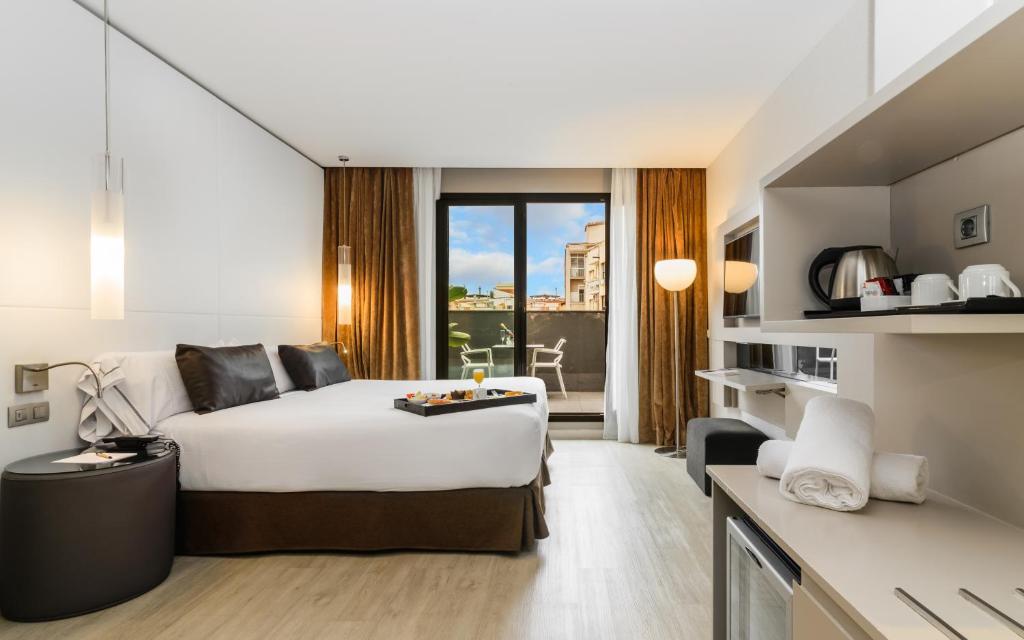 a hotel room with a bed and a large window at Grums Hotel & Spa in Barcelona