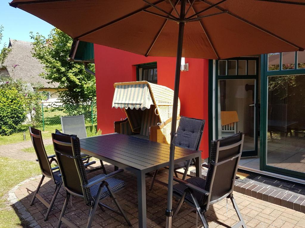 a table and chairs with an umbrella on a patio at Haus Sonnenwind in Zingst