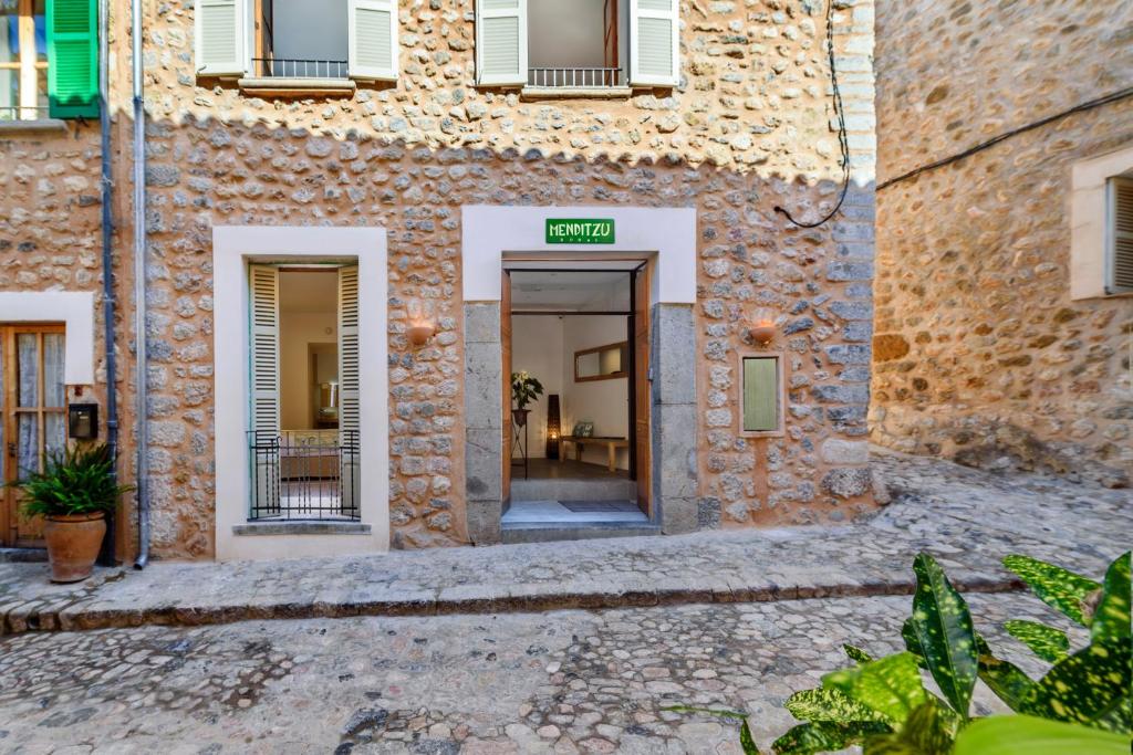 an entrance to a building with a sign that reads open at Menditzu Rooms in Biniaraix