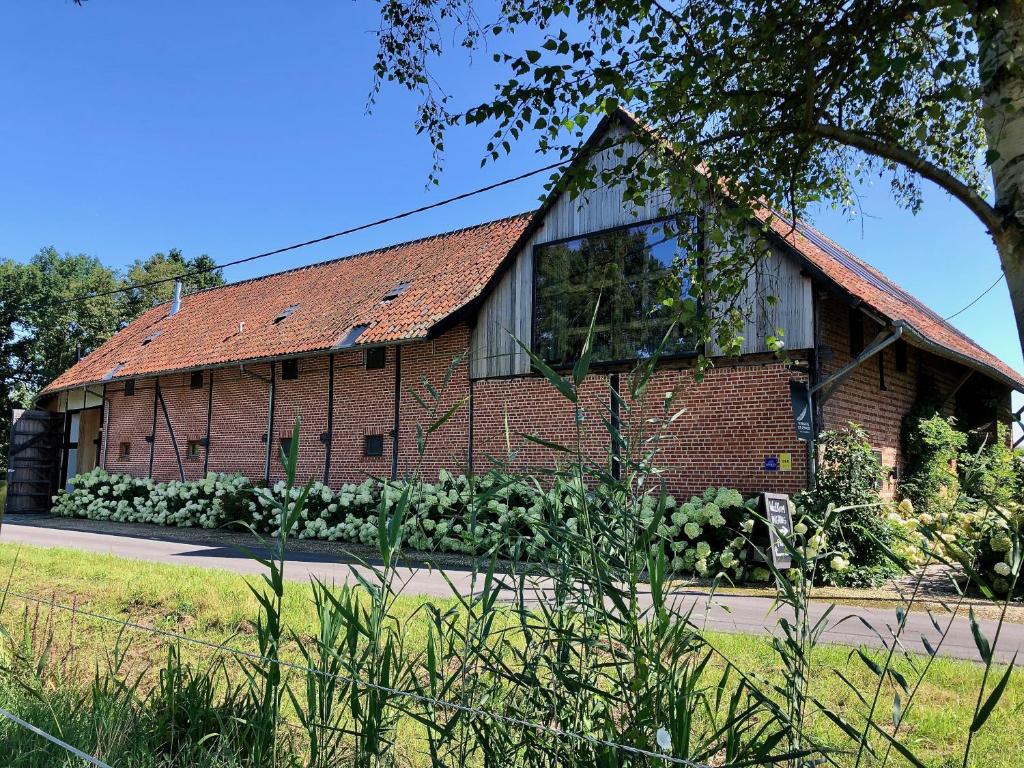 een bakstenen gebouw met een rood dak bij Winning De Zwaen in Hasselt