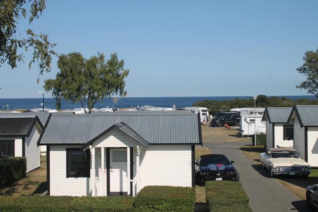 a row of white houses in a parking lot at Tobisviks Camping in Simrishamn