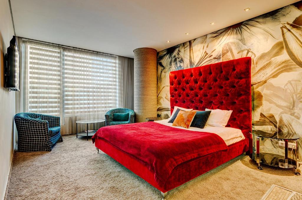 a bedroom with a red bed with a red headboard at Apartments with jaccuzi in Vilnius