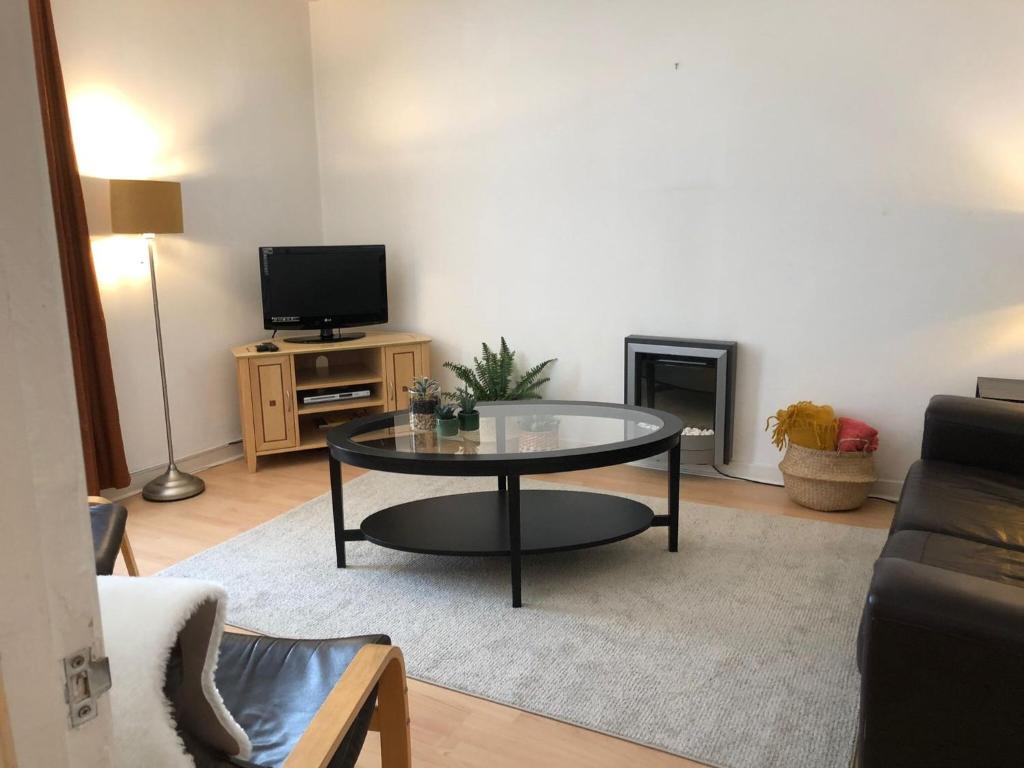 a living room with a coffee table and a tv at The Blair Street Residence in Edinburgh