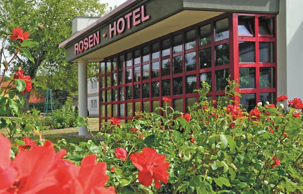 ein Hotel mit roten Blumen vor einem Gebäude in der Unterkunft Rosen-Hotel in Sangerhausen