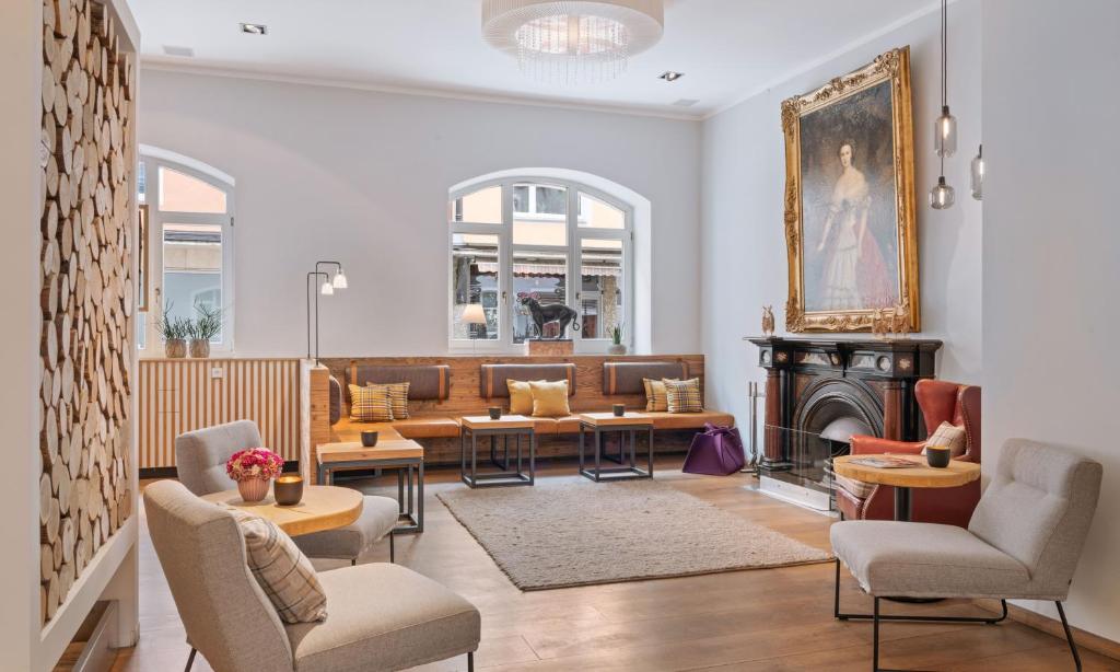 a living room with couches and a fireplace at Alpen Hotel München in Munich