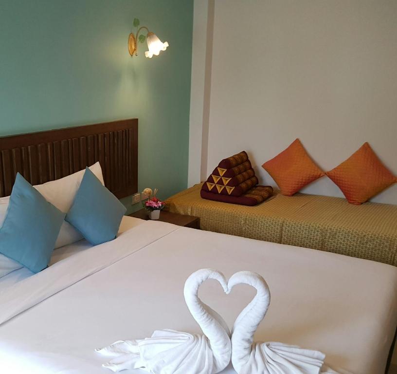 two swans are forming a heart on a bed at BS Airport at Phuket in Nai Yang Beach