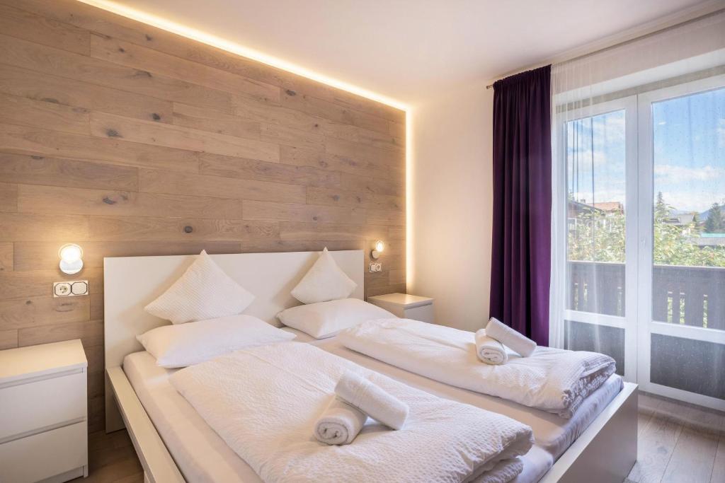1 dormitorio con 1 cama grande con almohadas blancas en Apt Hofer Elisabeth, en Villabassa