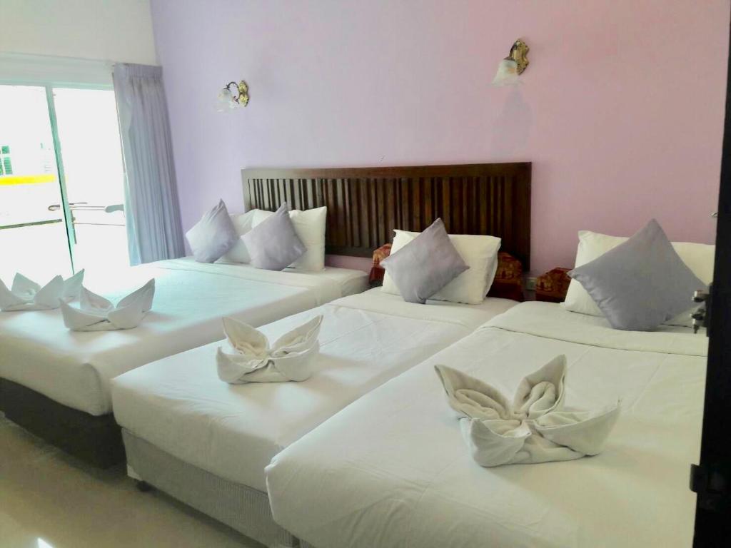 a room with three beds with white pillows on them at BS Airport at Phuket in Nai Yang Beach