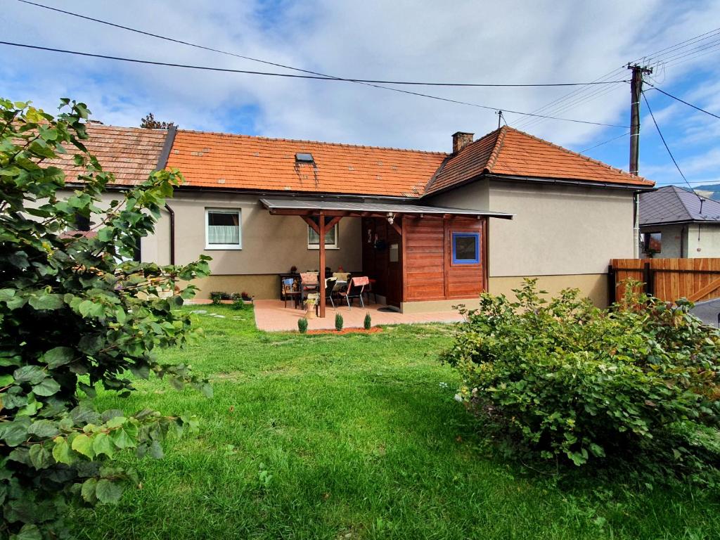 a house with an orange roof and a yard at Chalupa Margareta in Telgárt