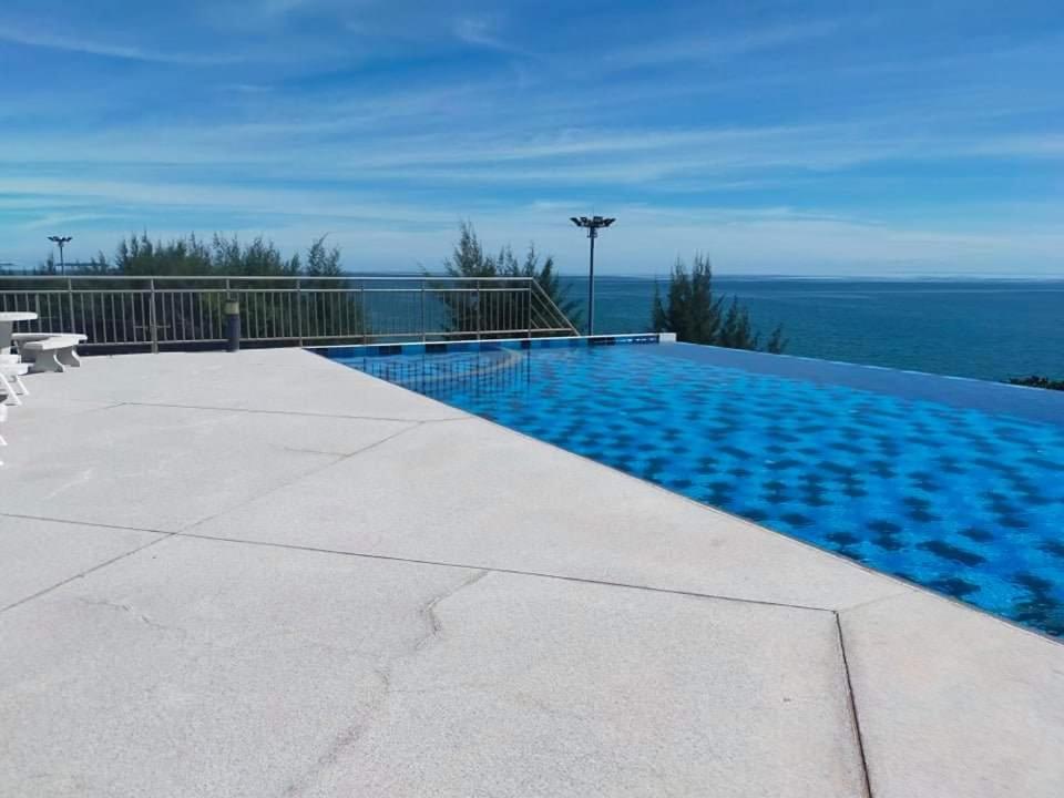 a swimming pool with a view of the ocean at Grandbeach 1 condo A202 in Rayong