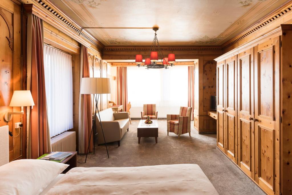 a bedroom with a bed and a living room at Chesa Languard in St. Moritz