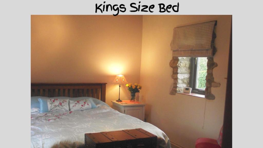 sypialnia z łóżkiem typu king-size i oknem w obiekcie Farm Stay -Nr Silverstone, Bicester Village and Stowe w mieście Hinton in the Hedges