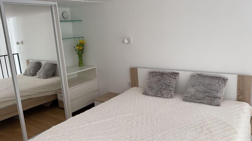 a bedroom with a white bed and a mirror at Loft in city center-Prime rentals in Kaunas