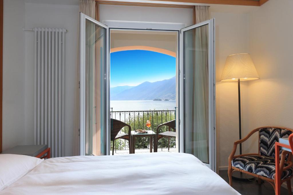 a bedroom with a bed and a view of the water at Albergo Carcani by Ketty & Tommy in Ascona