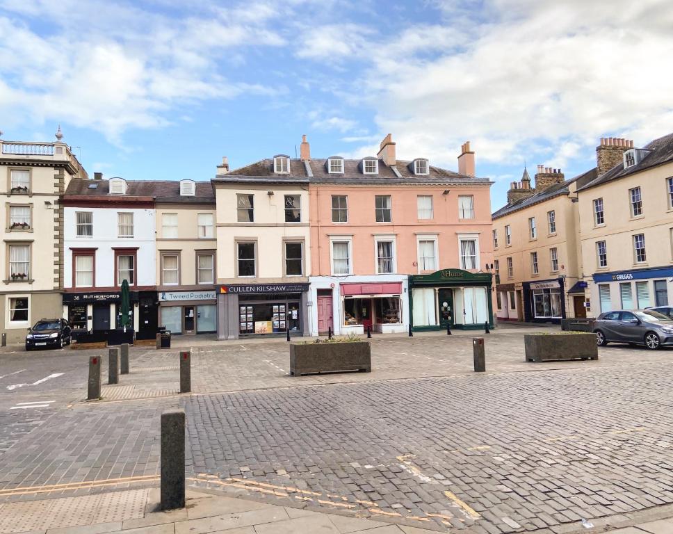 a group of buildings in a city with a street at Studio Apartments on the Square in Kelso