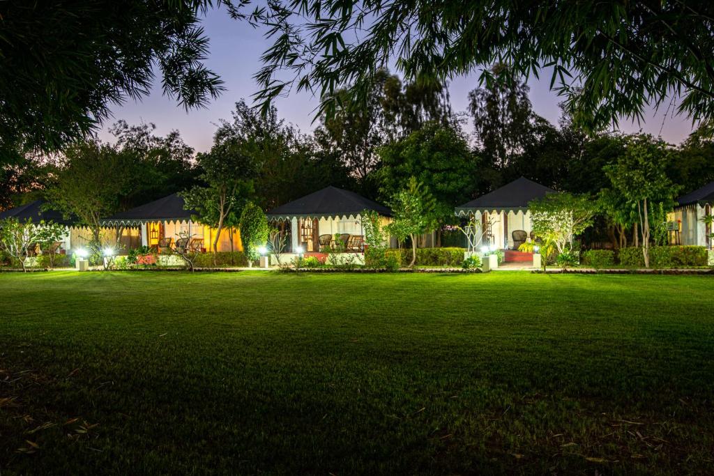 a large lawn in front of a house at night at Jungle Cave Resort in Sawāi Mādhopur