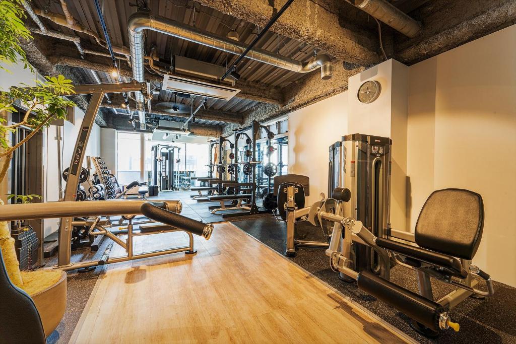 un gimnasio con varias cintas de correr y máquinas de ejercicio en obi Hostel, en Tokio