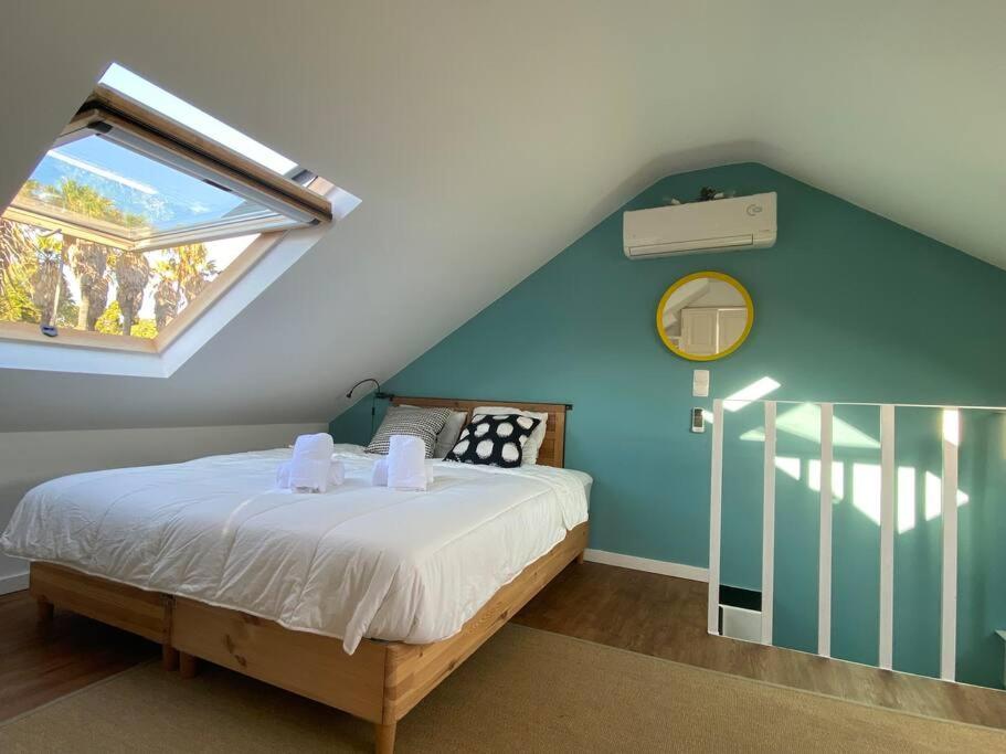 1 dormitorio con 1 cama con pared azul y ventana en Belém Fantastic Triplex House en Lisboa