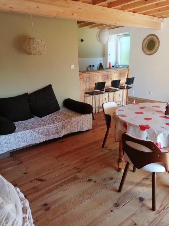 a living room with a table and a couch at La villa verte in Beaulieu