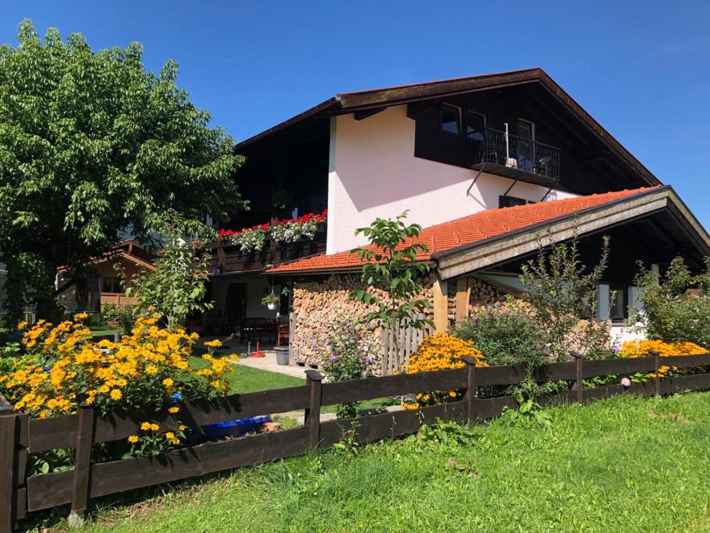 a house with a fence and flowers in front of it at Landhaus Hochgern in Unterwössen