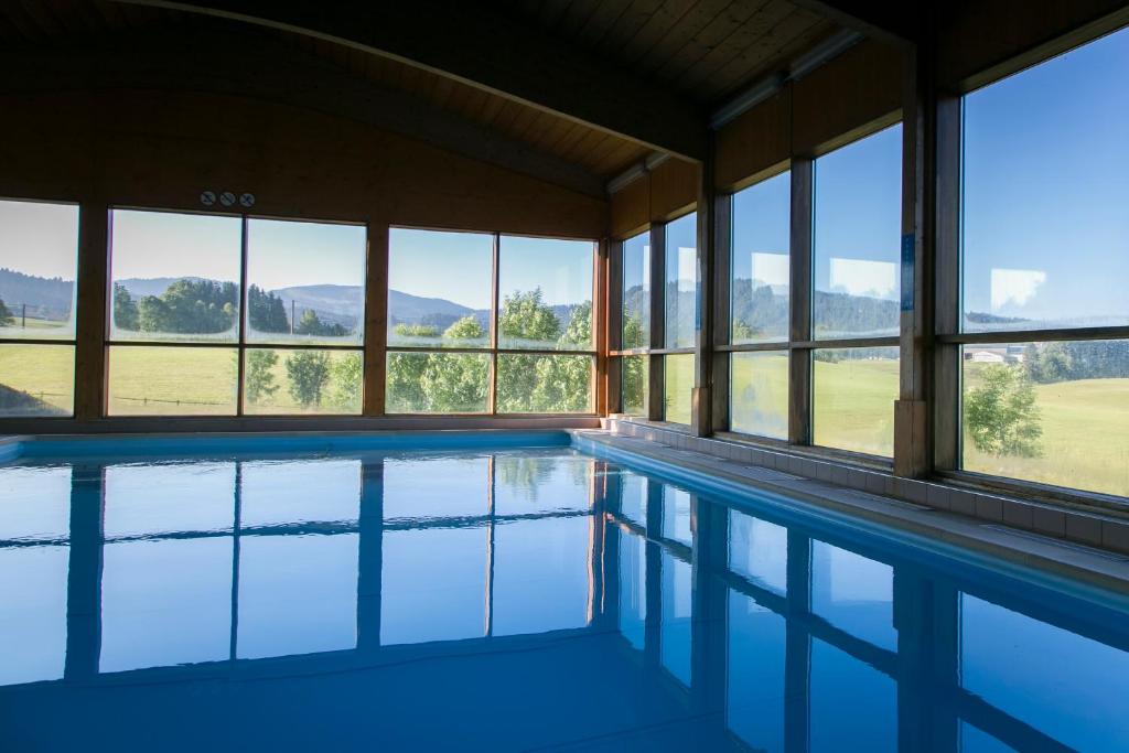a swimming pool in a house with windows at Résidence Les Clarines ( by Popinns ) in Les Rousses