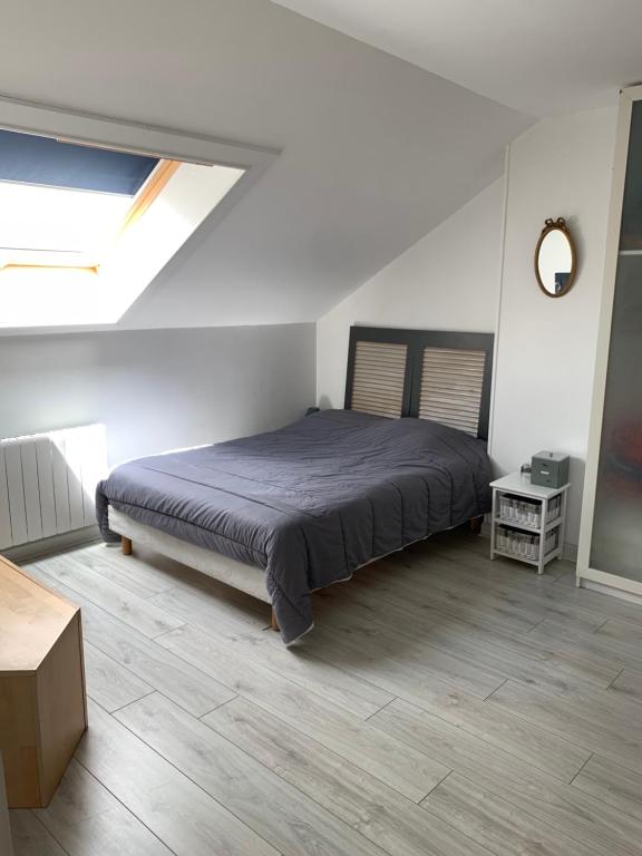 a bedroom with a large bed in a white room at Les chambrées de Sergine in Jonchery