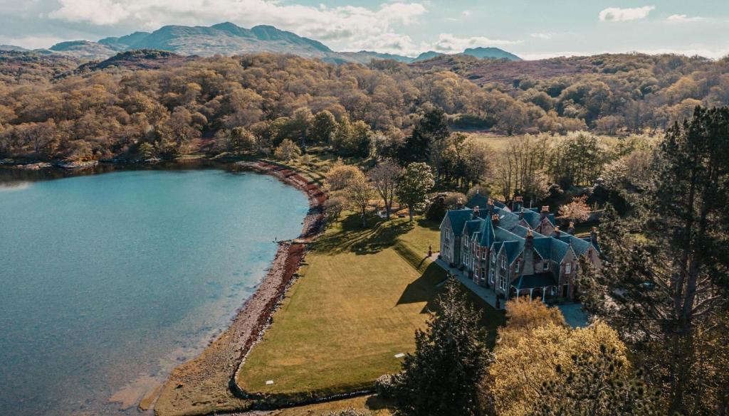 an aerial view of a house next to a lake at Shieldaig Lodge Hotel in Gairloch