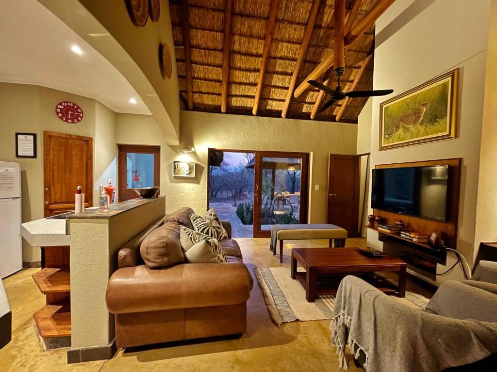 a large living room with a couch and a kitchen at 10 Raptors Lodge in Hoedspruit