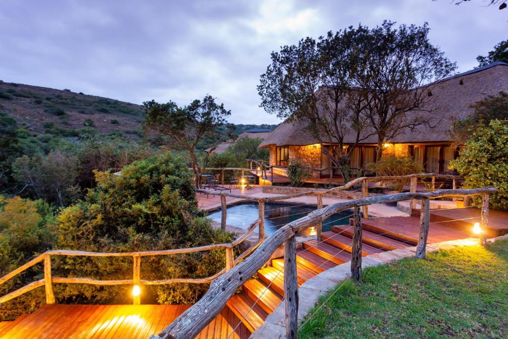 a house with a bridge over a river with lights at Lalibela Game Reserve Mark's Camp in Paterson