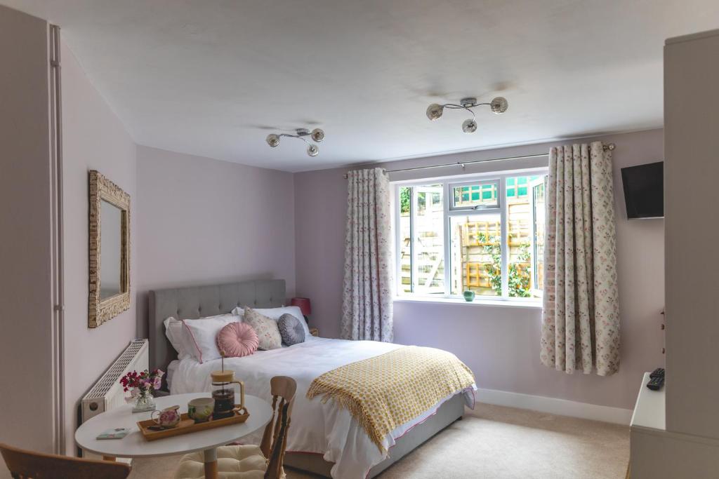 a bedroom with a bed and a table and a window at The Costrel in Tenbury