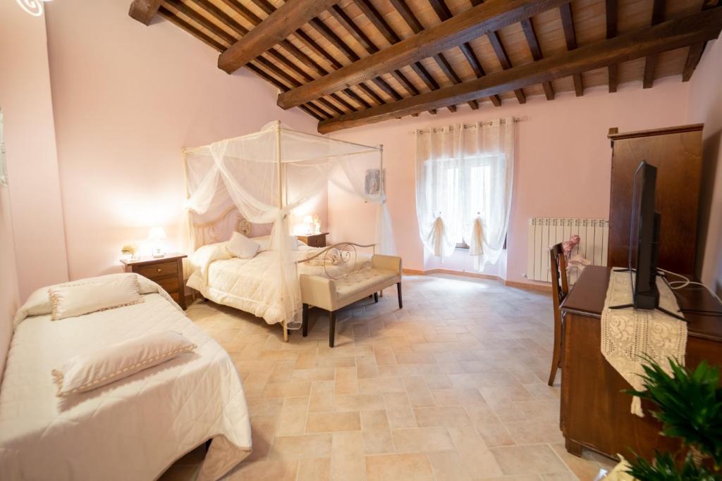 sypialnia z 2 łóżkami i telewizorem z płaskim ekranem w obiekcie Albergo La Loggia di San Martino w mieście Gualdo Tadino