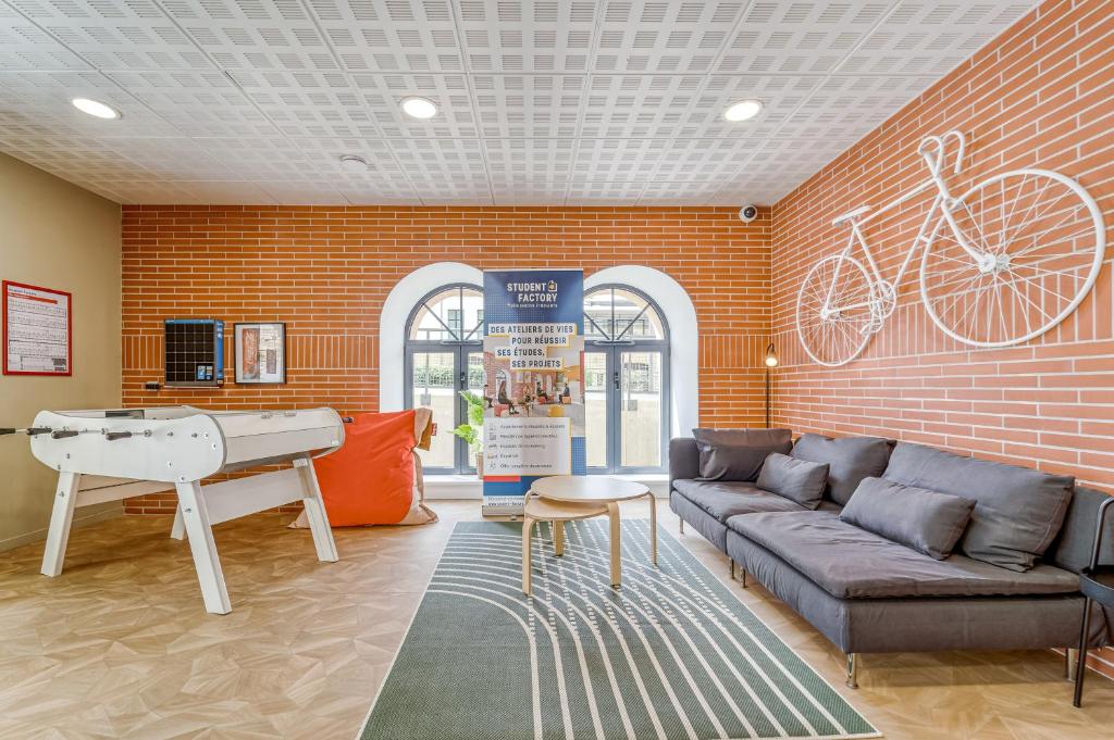 ein Wohnzimmer mit einem Sofa und einer Tischtennisplatte in der Unterkunft Student Factory Metz Trèves in Metz