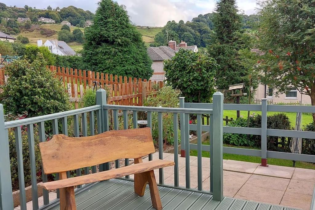 a wooden bench sitting on top of a balcony at Hazel's House in Keighley