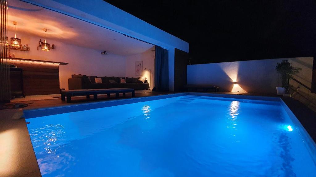 ein großer Pool in einem Wohnzimmer in der Nacht in der Unterkunft Green Charm House Lisbon in Lissabon