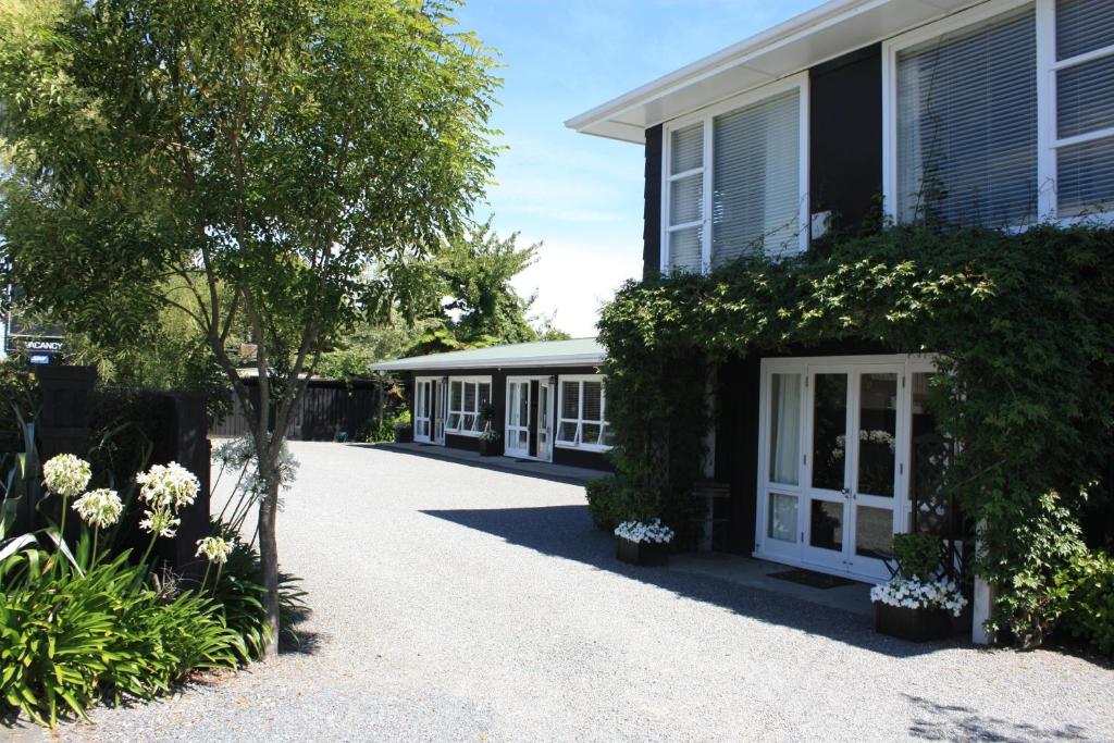 ein Haus mit weißen Türen und einer Auffahrt in der Unterkunft The Lake Motel in Taupo
