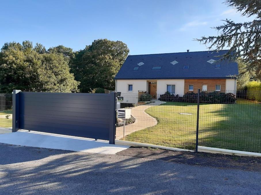 um portão de metal em frente a uma casa em chambre d'hôtes Les Hortensias em Saint-Jean-la-Poterie