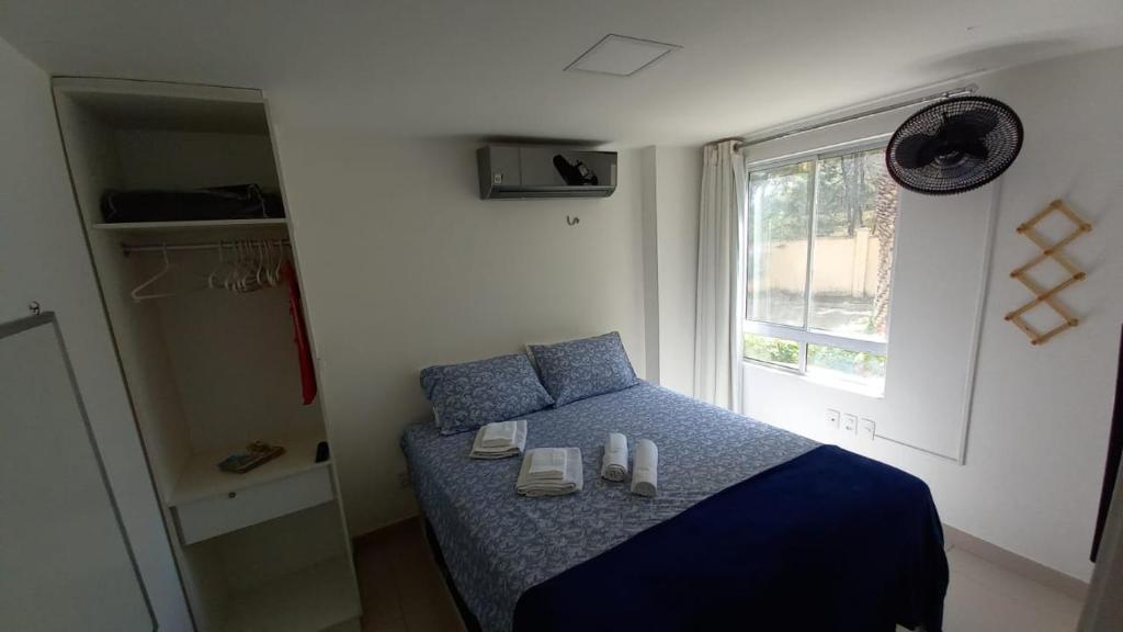 a bedroom with a bed with shoes and a window at Riviera Beach Place - Aquiraz Riviera in Fortaleza