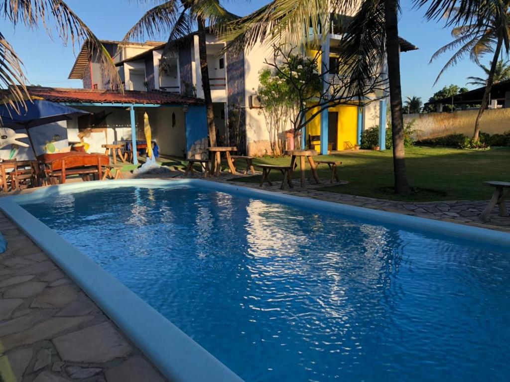 a swimming pool in front of a house at Pousada Sol e Mar Buzios RN in Nísia Floresta