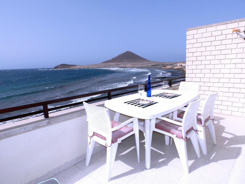 a white table and chairs on a balcony with the ocean at Apartamento Costa Roja Views in El Médano