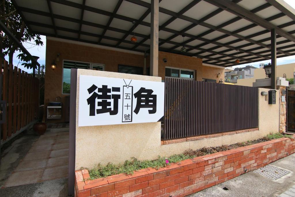 a sign in front of a house with a fence at Corner No50 Hostel in Taitung City
