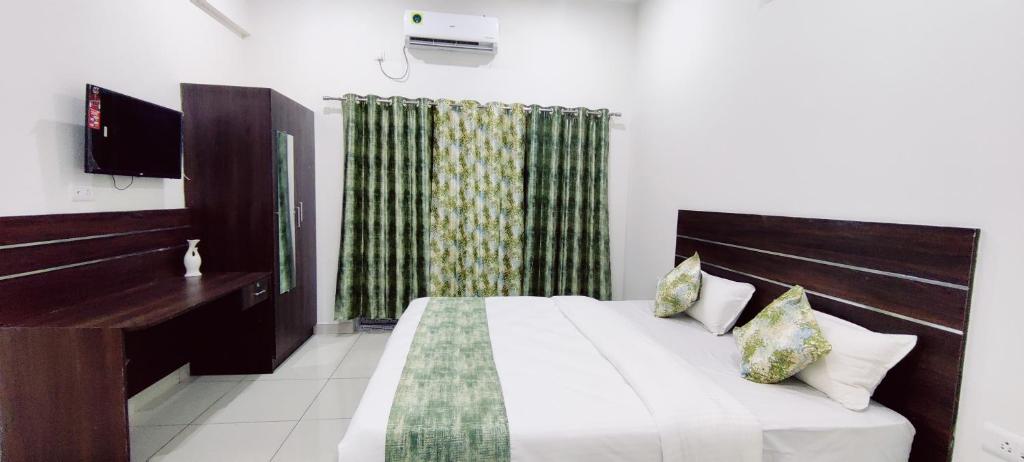 A bed or beds in a room at Suvarna Elite - Premium Apartment Hotel