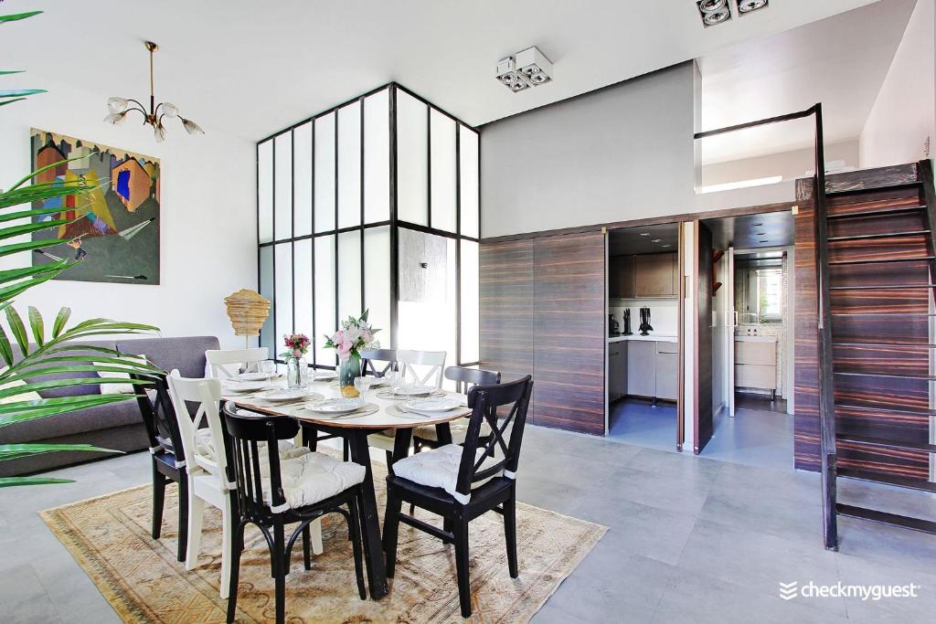 a dining room with a table and chairs at Superbe Loft 2BR - Buttes Chaumont in Paris