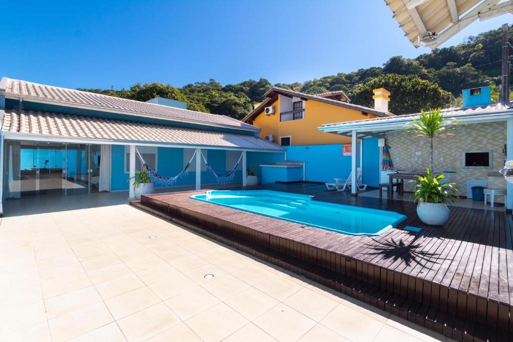 a backyard with a swimming pool and a house at CASA COM PISCINA EM MORRINHOS - RUA HORTÊNCIA in Bombinhas