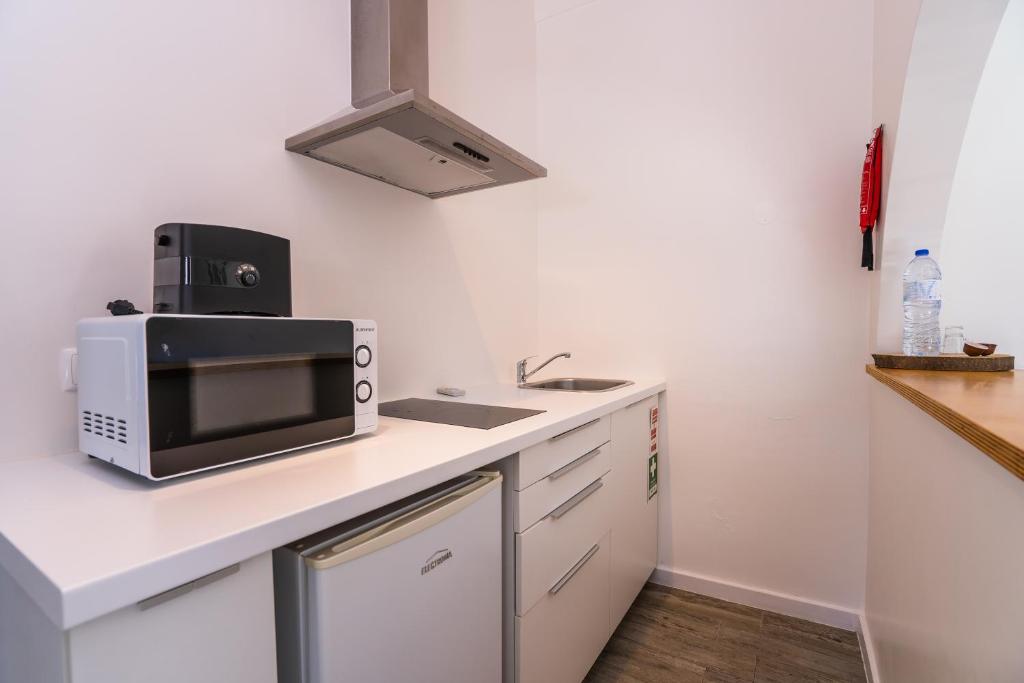 a kitchen with a microwave and a sink at Quinta da Bicuda in Cascais