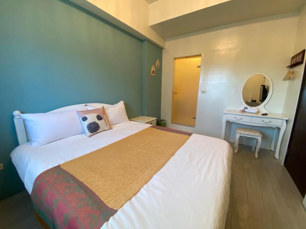 a bedroom with a large bed and a mirror at Beauty Home Homestay in Hualien City