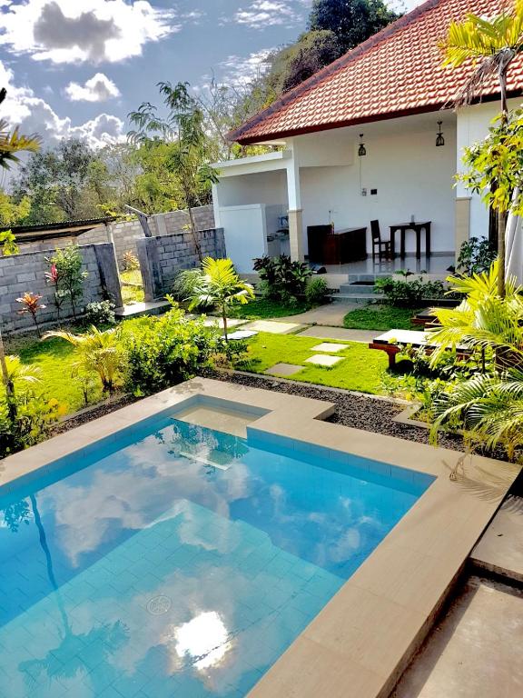 a swimming pool in front of a house at Sunburn Villa in Nusa Dua