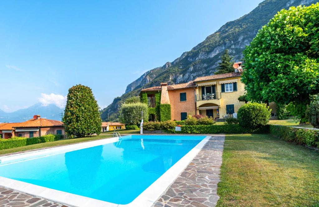 - une piscine en face d'une maison avec une montagne dans l'établissement SARA E MELISSA HOUSE LIERNA, à Lierna