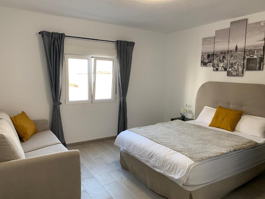 1 dormitorio con cama, ventana y sofá en Villa Rosaura en Las Palmas de Gran Canaria