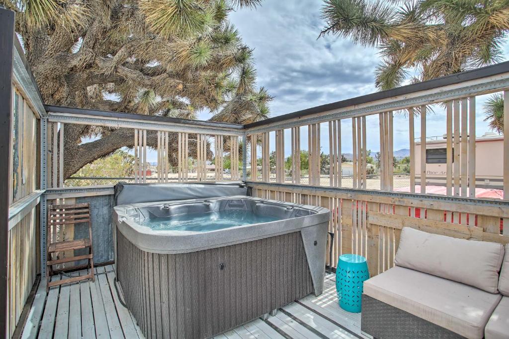 a hot tub on a deck with a tree at Yucca Valley Oasis with Hot Tub, Near Joshua Tree! in Yucca Valley