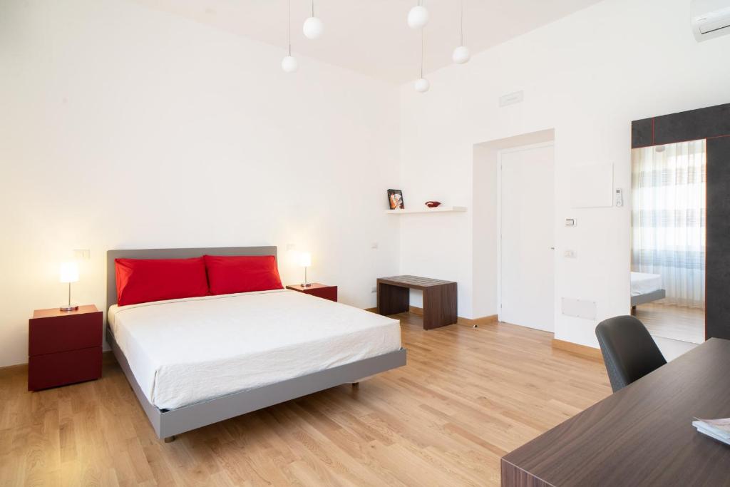 卡利亞里的住宿－L'isola che c'è，一间卧室配有一张带红色枕头的床和一张桌子
